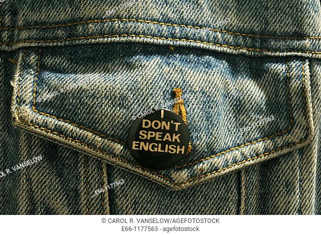 button saying 'I don't speak English' on pocket of blue jean jacket