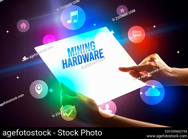 Holding futuristic tablet with MINING HARDWARE inscription, new technology concept