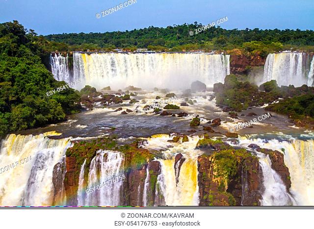 The concept of extreme and exotic tourism. Iguazu Falls National Park - grandiose complex of waterfalls. Multistage system of waterfalls creates rainbow