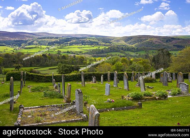 The graveyard in the village of Selworthy with the rolling hills of Exmoor and Dunkery Hill beyond. Somerset, England, Great Britain