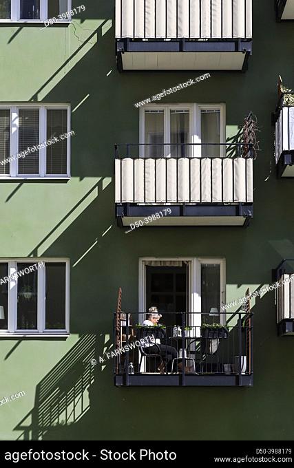 Stockholm, Sweden A woman sits on her balcony in the sun in the Kristineberg district