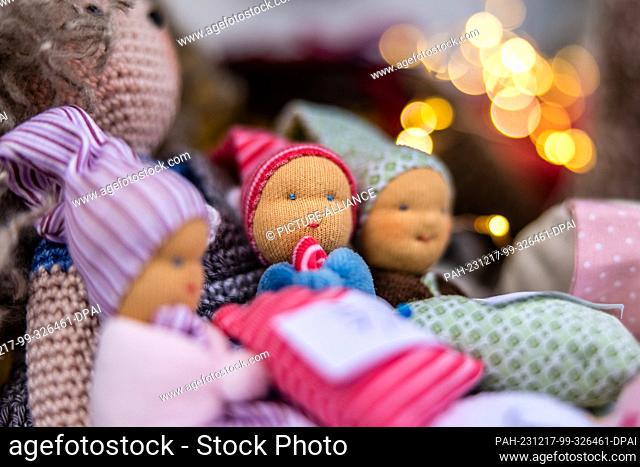 16 December 2023, Brandenburg, Leuthen: Handmade knitted and sock dolls are on display at a stall at a small Advent market