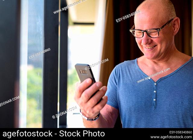 Portrait of senior handsome Scandinavian man relaxing inside the hotel bedroom