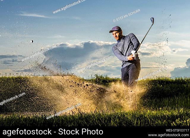Man playing golf standing on grass
