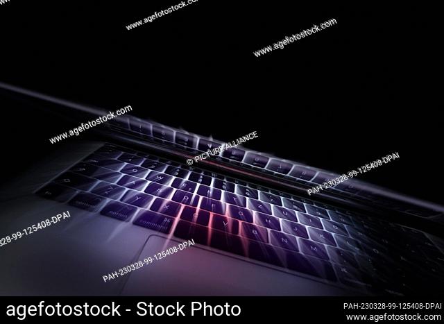 28 March 2023, Bavaria, Kempten: ILLUSTRATION - The keyboard of a laptop is reflected in its screen (recording with zoom effect)