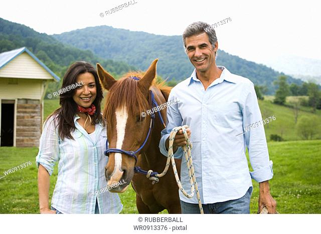Portrait of a mature man and a woman with a horse