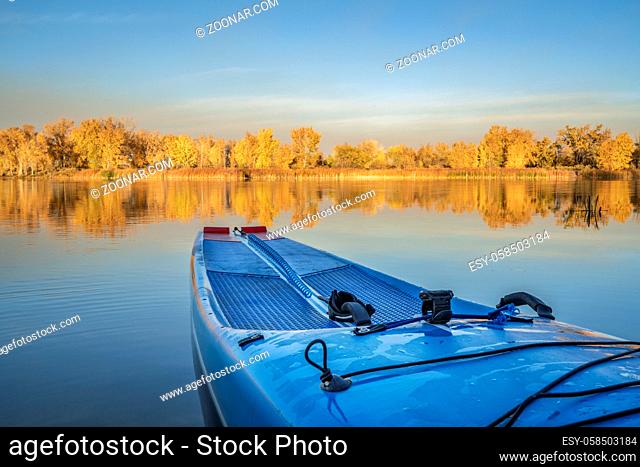 Racing stand up paddleboard with a safety leash on a calm lake in fall scenery in northern Colorado