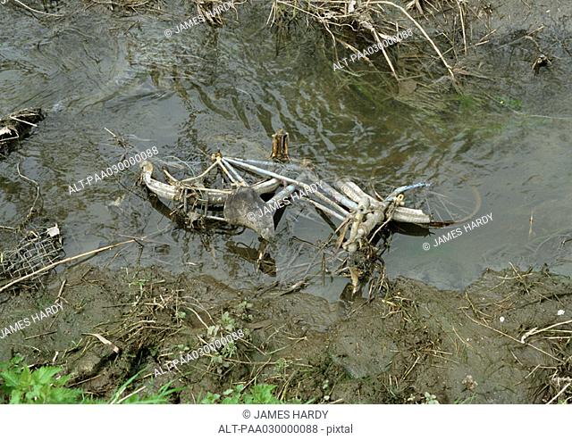 Bicycle submerged in mud and water