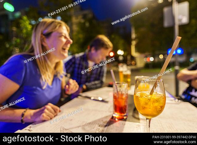PRODUCTION - 29 September 2023, Hesse, Frankfurt/Main: People sit in the outdoor area of a restaurant in the city center