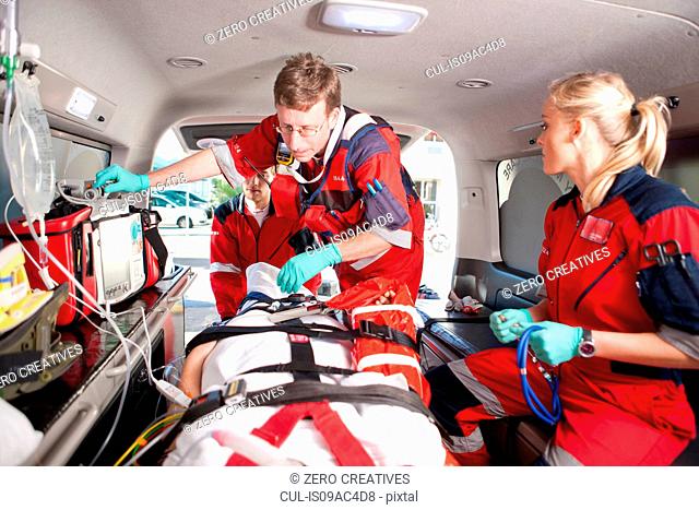 Paramedics checking patient in ambulance