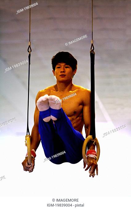 Young man practicing gymnastic rings