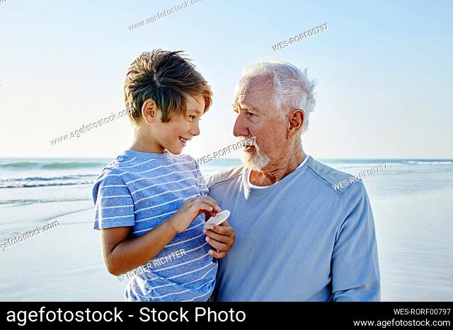 Grandfather with grandson on the beach