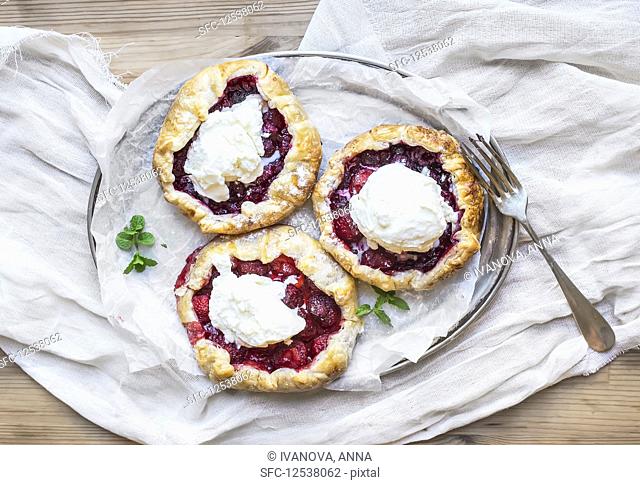 Rustic small galeta pies with fresh berries and vanilla ice-cream