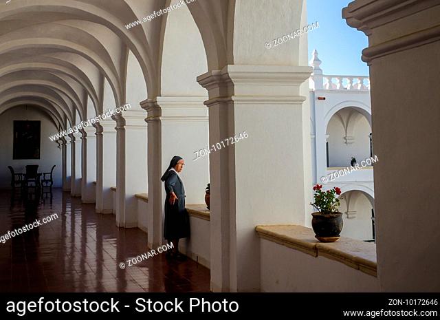Sucre, Bolivia in September 2015: A nun looks out of a window in a convent. The convent is a beautiful colonial building in Bolivias capital