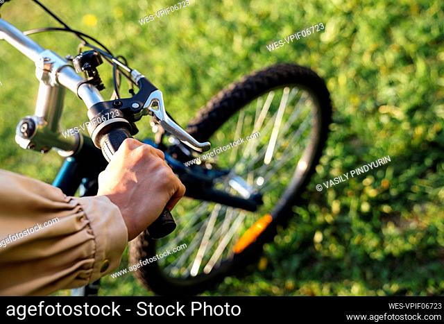 Hands of woman on handlebar in park