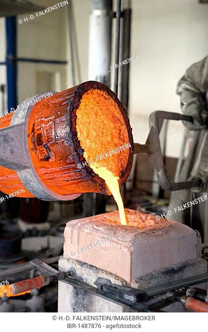 Liquid bronze at 1250° C is being poured into a mold in an art bronze foundry
