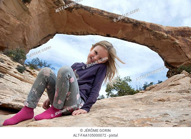 Girl sitting near Owachomo Bridge, Natural Bridges National Monument, Utah, USA