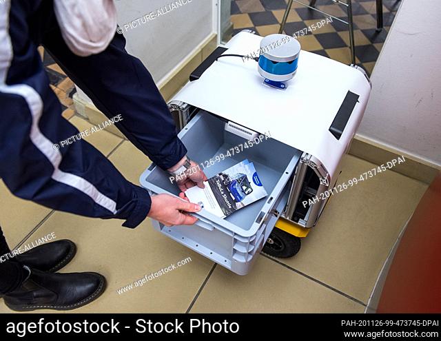26 November 2020, Schleswig-Holstein, Lauenburg/Elbe: A prototype of a transport robot is filled with mail during a press event at a loading point