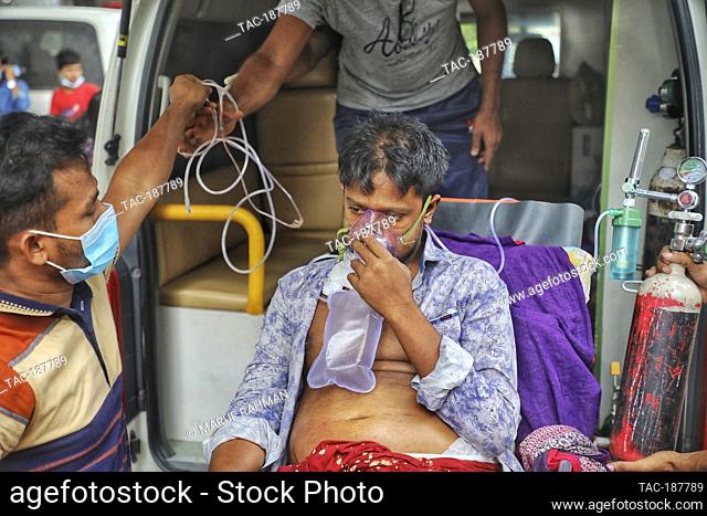 DHAKA, BANGLADESH - AUGUST 3: A patient is transport in ambulance to Dhaka Medical Hospital, to health workers treats the patient in the intensive care unit...