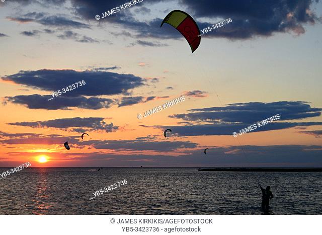 A kite surfer brings in his kite at the end of the day