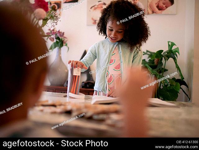 Smiling girl coloring at dining table