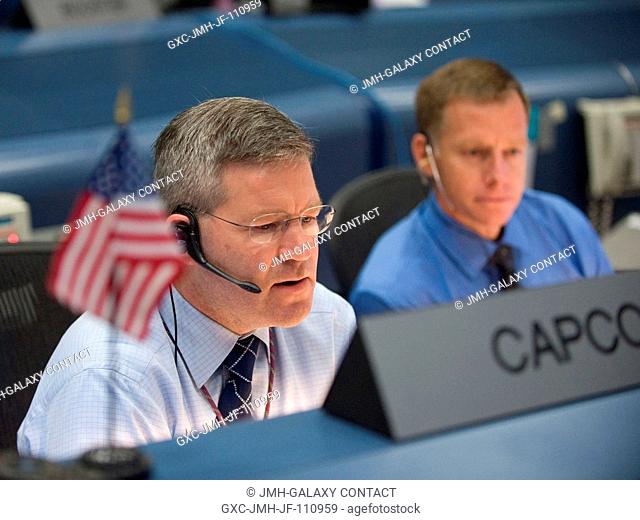 Astronauts Steve Frick (left) and Chris Ferguson, STS-129 spacecraft communicators (CAPCOM), are pictured at their console in the space shuttle flight control...