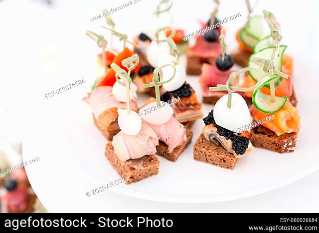 the buffet at the reception. Assortment of canapes. Banquet service. catering food, snacks with fish, vegetables and meat. rye, wheat bread