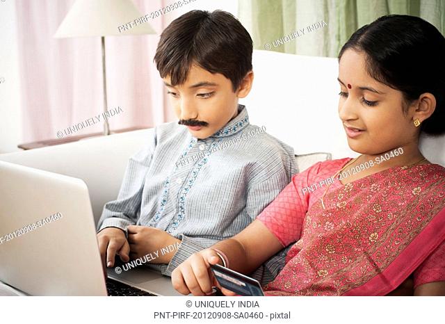 Children imitating like couple doing online shopping with a laptop