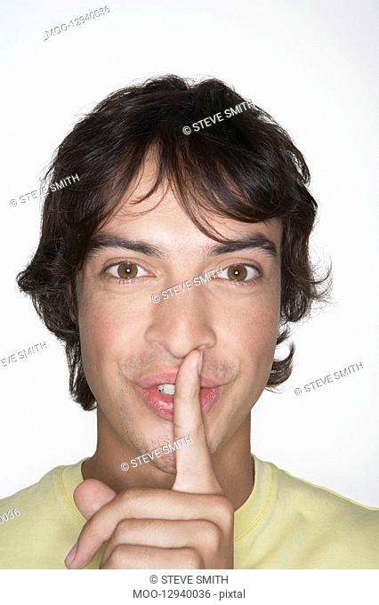 Man with Finger on Lips grinning close-up