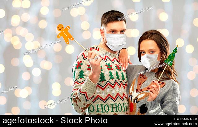 couple in medical masks and christmas sweaters