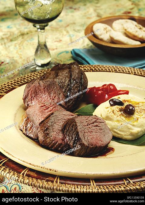 Grilled petite tenderloin of beef with mashed potatoes in a mediterranean setting