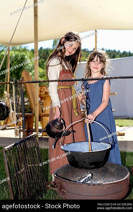 10 August 2022, Mecklenburg-Western Pomerania, Sternberg: Livia (r) and Juna pose on the open-air grounds of the Groß Raden Archaeological Open-Air Museum