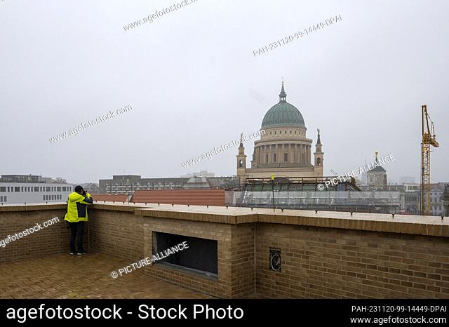 20 November 2023, Brandenburg, Potsdam: A participant on the tour stands on the roof terrace on the construction site of the Jewish synagogue and community...