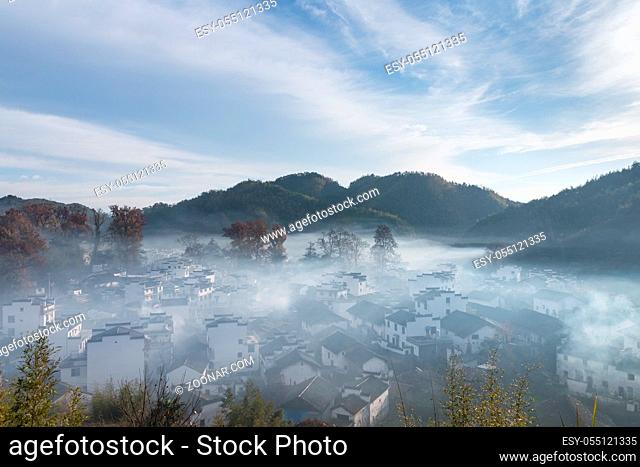 wuyuan landscape of shicheng village in morning, smoke and mist on beautiful countryside, China