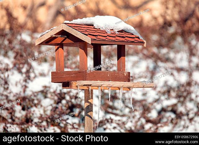homemade wooden birdhouse, bird feeder installed on winter garden