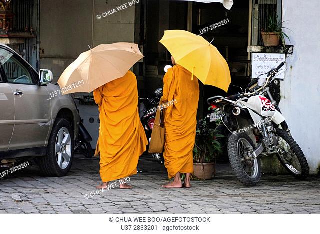 Two Buddhist novices collect alms in Phnom Penh City, Cambodia