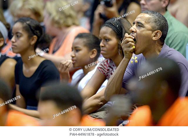 United States President Barack Obama enjoys some popcorn as he, first lady Michelle Obama and daughters Malia Obama and Sasha Obama attend the Hawaiian Airlines...