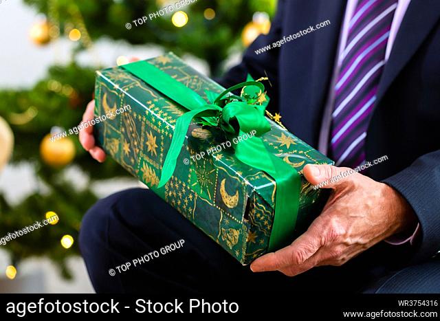 Senior man celebrating Christmas with present