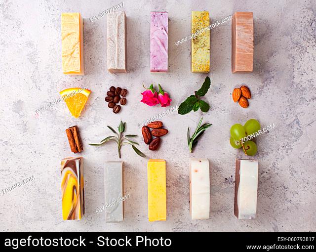 Top view of various handcrafted organic soap with different natural ingredients, main components, in row on light grey marble background
