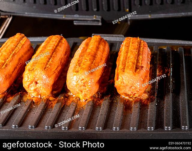 Plant-based vegetarian Sausages being grilled on griddle