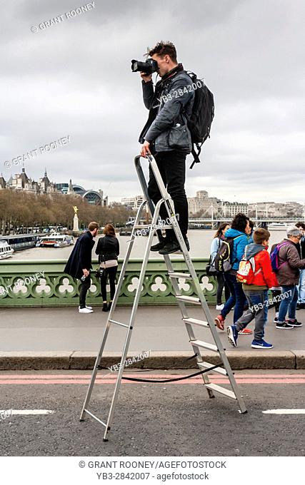 A Photographer Stands On A Step Ladder To Take Photographs Of People On Westminster Bridge A Week After The Terror Attack, London, UK