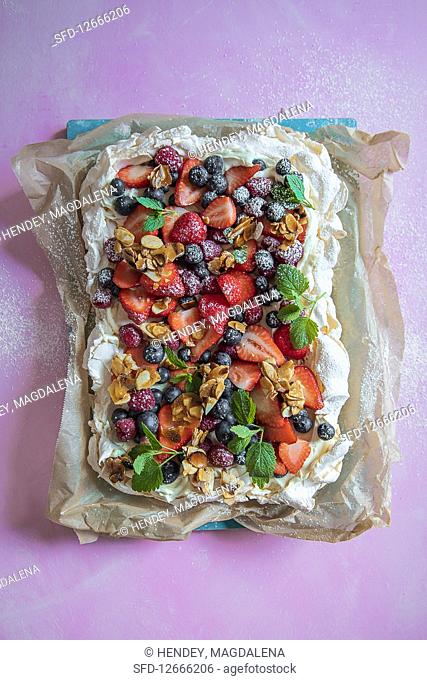 Pavlova with cream, fresh berries and almond brittle