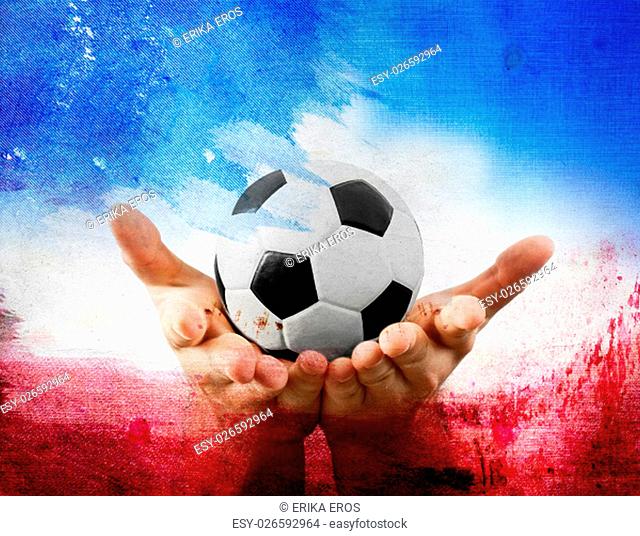 Soccer ball in the hands of a man on red, blue, and white background
