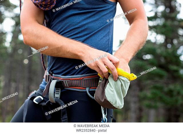 Midsection of man with chalk bag