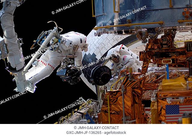 With his feet secured on a platform connected to the remote manipulator system (RMS) robotic arm of the Space Shuttle Columbia, astronaut Michael J