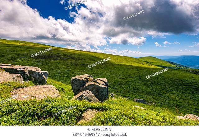 giant boulders on grassy slopes of Polonina Runa. beautiful summer scenery in Carpathian mountains with gorgeous cloudscape