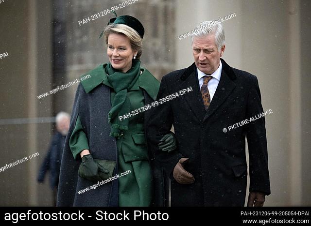 05 December 2023, Berlin: Queen Mathilde of Belgium and King Philippe of Belgium walk past the Brandenburg Gate during a visit by the Belgian royal couple to...