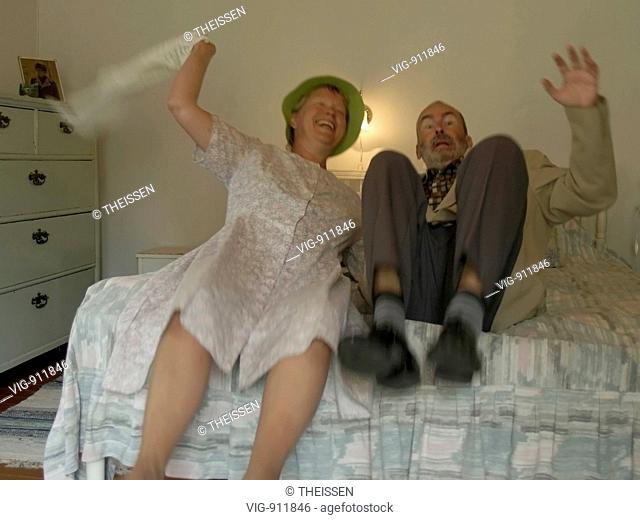 old bizarre strange couple in an antiquated bed room laughing and falling in the bed . - 31/07/2006