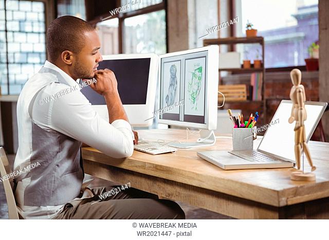 Cartoonist looking at designs on computer