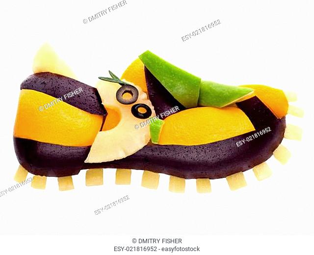 Fruits and vegetables in the shape of a shoe strainer isolated on white